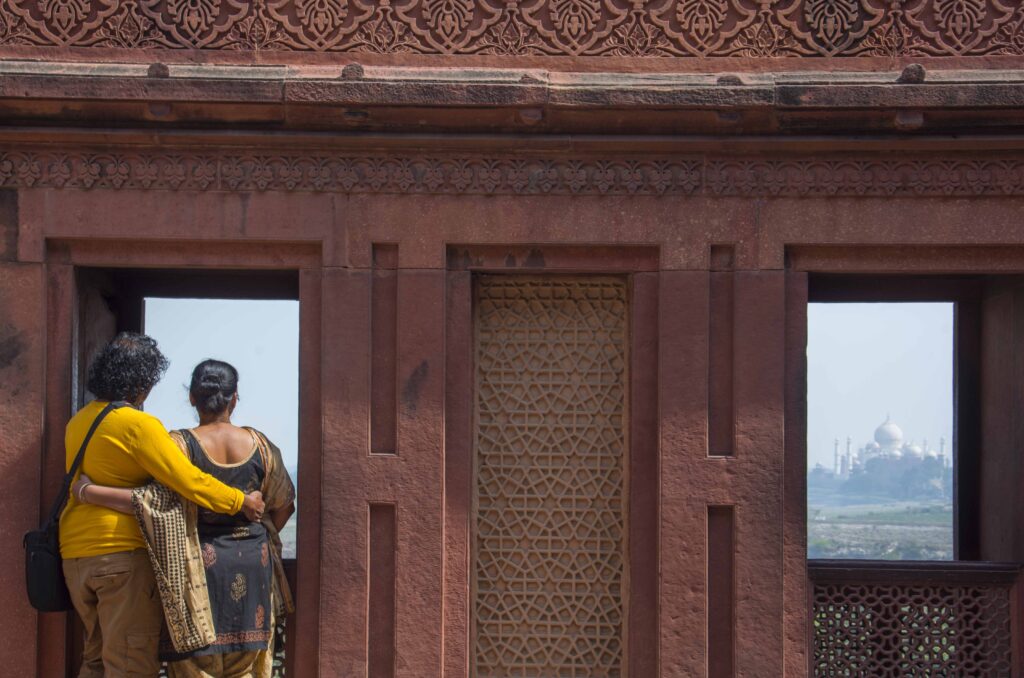 late married couple looking at Taj mahal.​